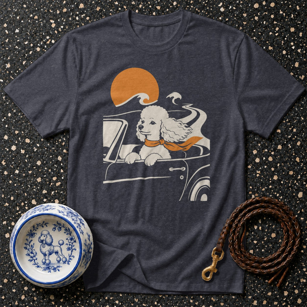 Dark t-shirt with graphic of a poodle in a car with an orange scarf and sunset.