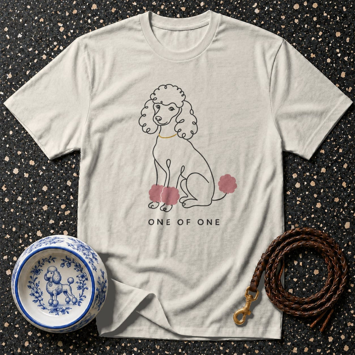 T-shirt with line drawing of a poodle wearing a gold collar, with pink accents.