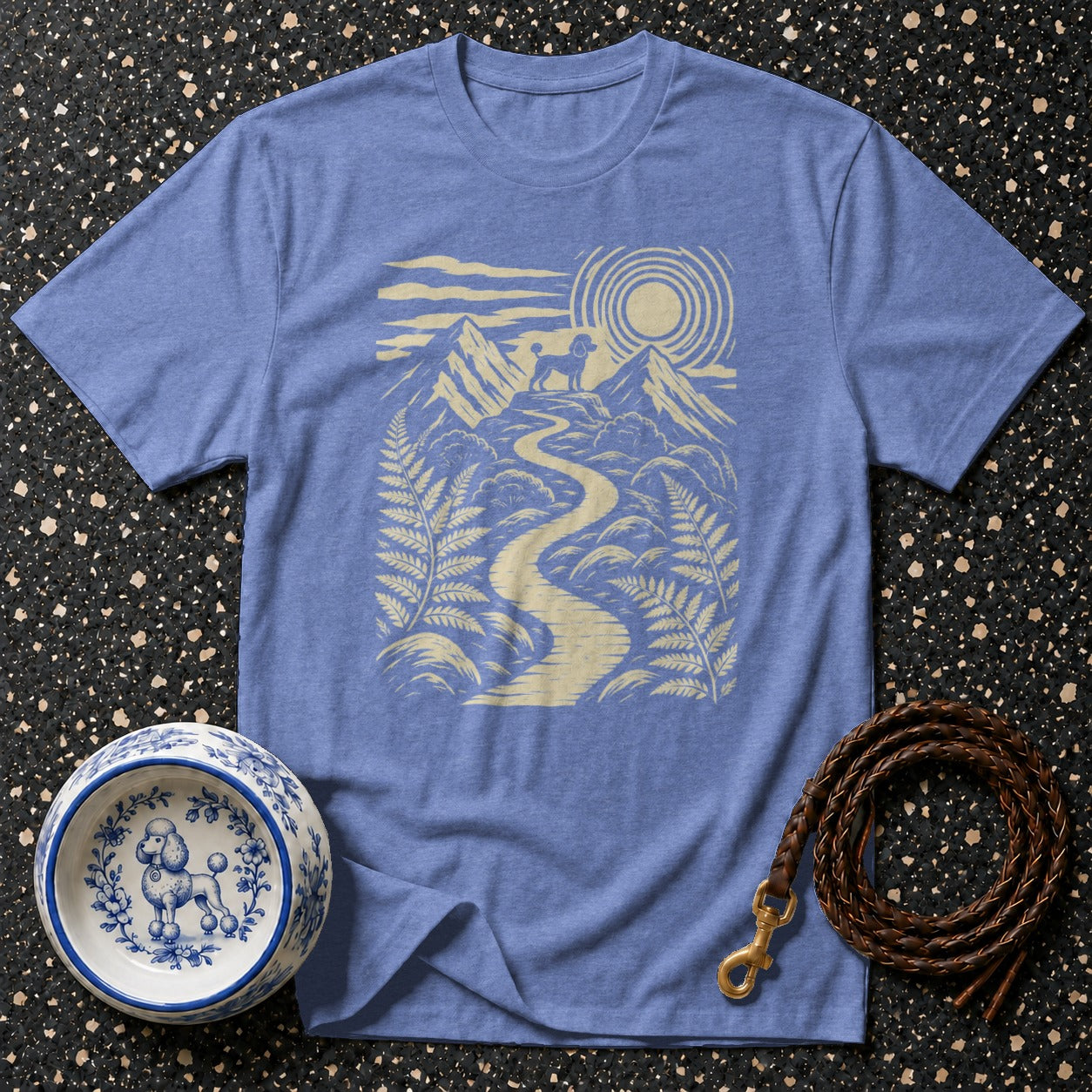 Blue t-shirt with a nature scene featuring a poodle, mountains, and a winding path.