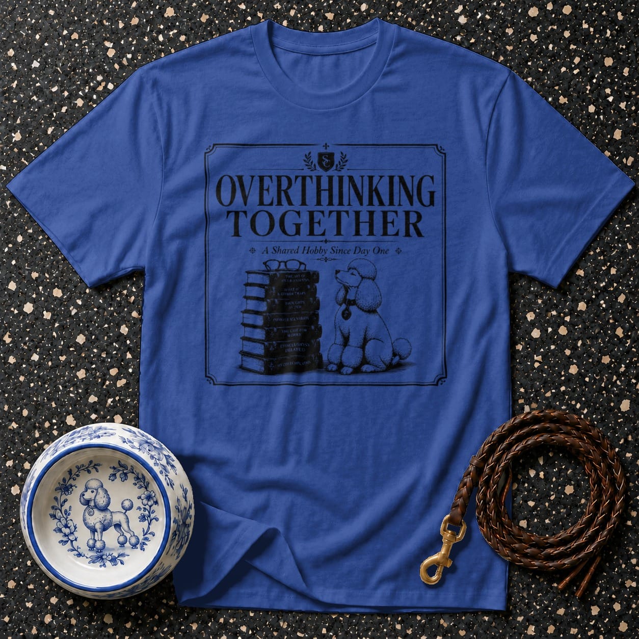 Blue t-shirt with a dog sitting next to a stack of books and the text "OVERTHINKING TOGETHER".