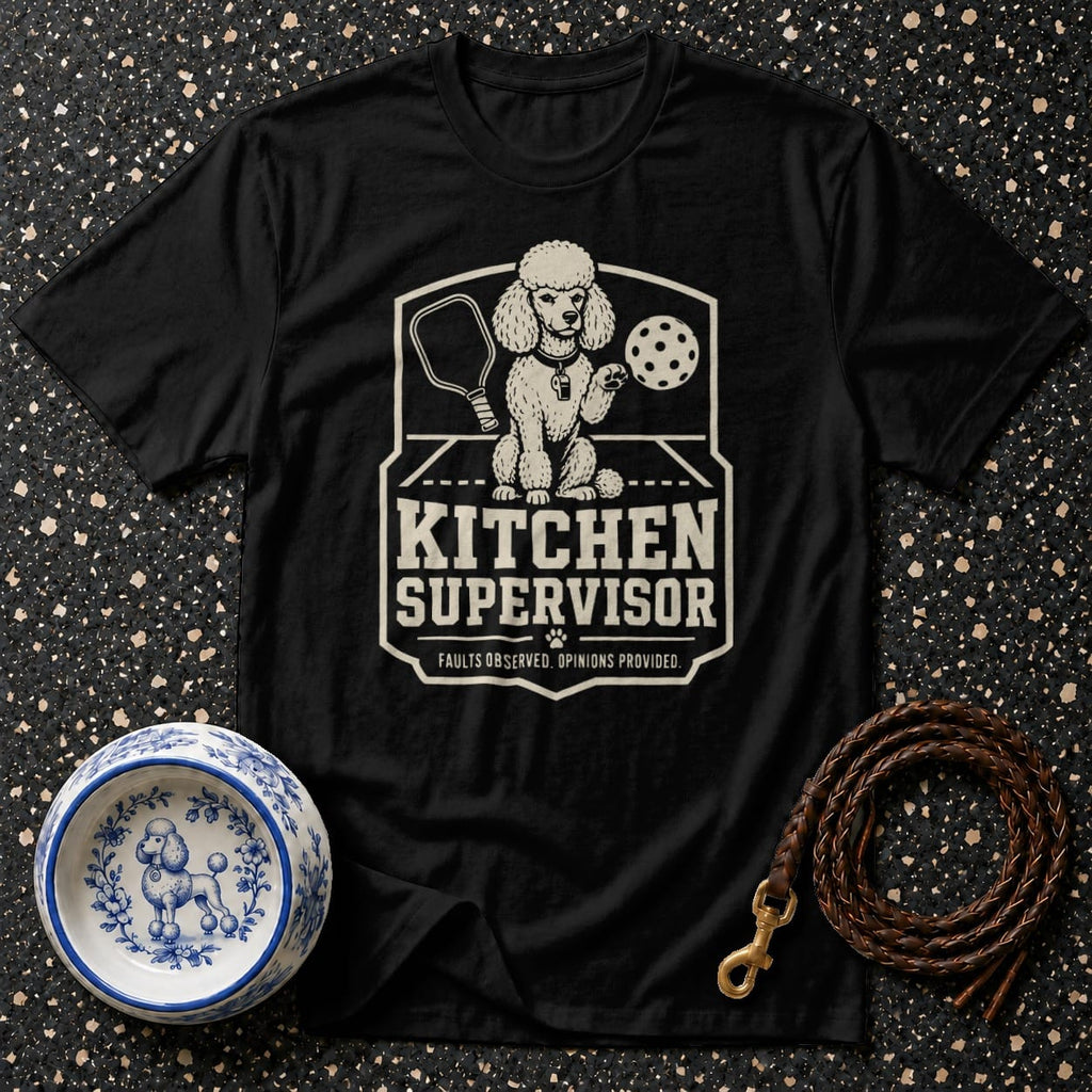 Black t-shirt with a graphic of a poodle holding a pickleball paddle and ball.