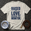 Cream t-shirt with navy text "RAISED TO LOVE. BORN TO MONITOR."