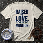 Cream t-shirt with navy text "RAISED TO LOVE. BORN TO MONITOR."