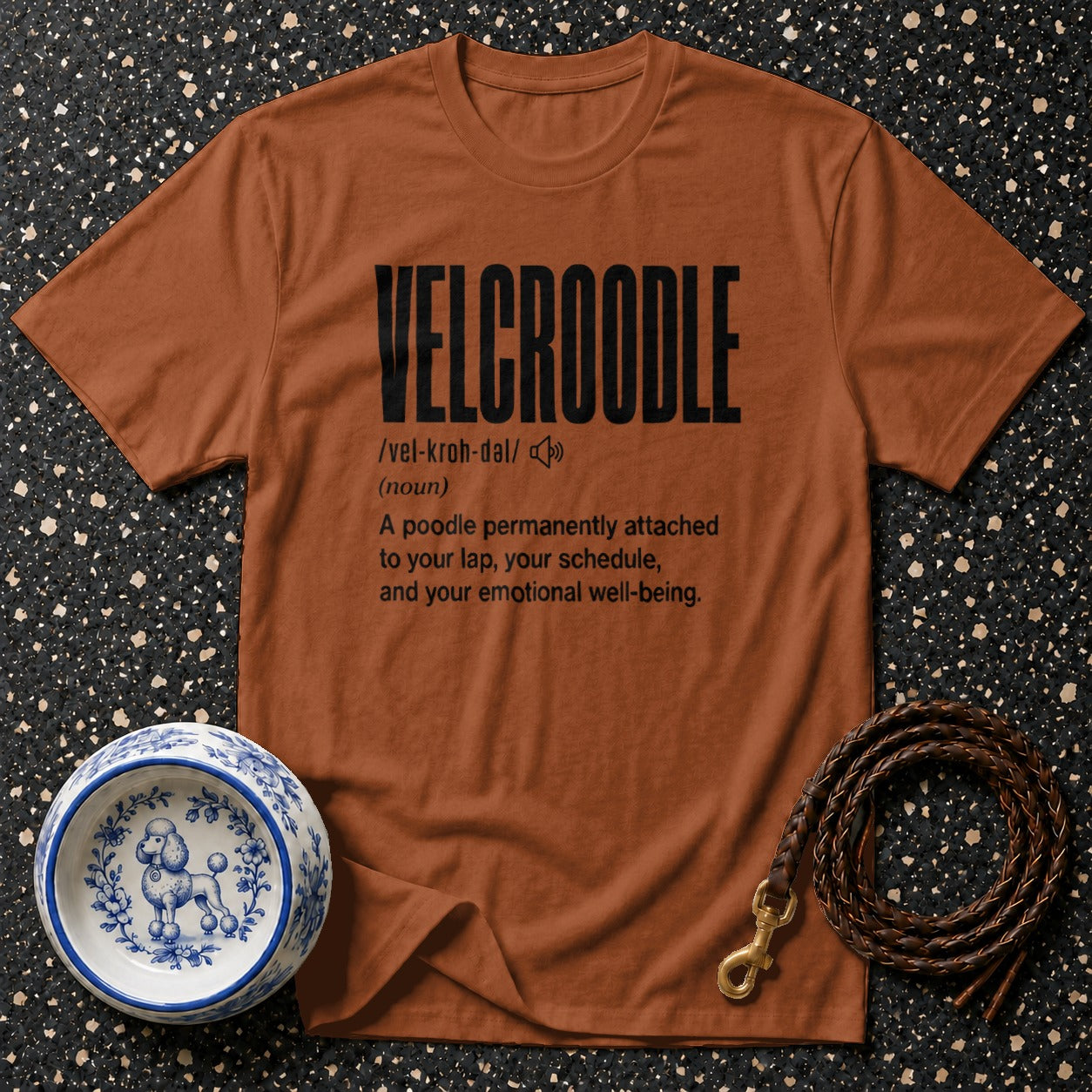 Brown t-shirt with "VELCROODLE" definition and poodle-themed accessories.