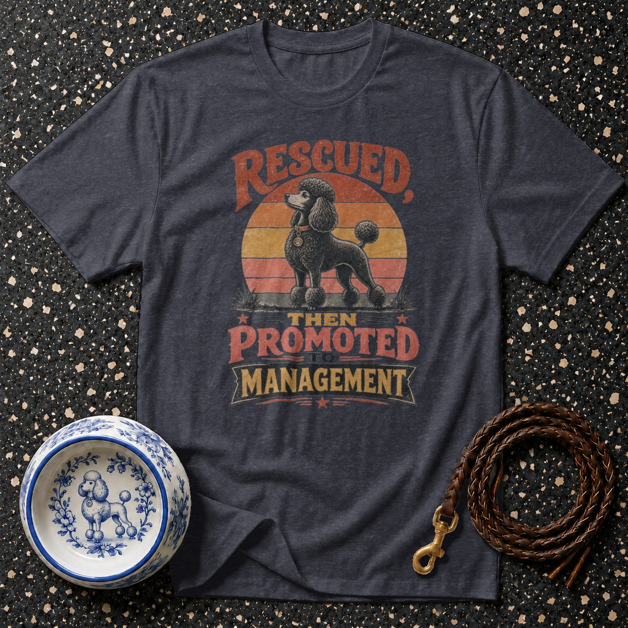 Dark grey t-shirt with vintage "rescued then promoted to management" poodle graphic.