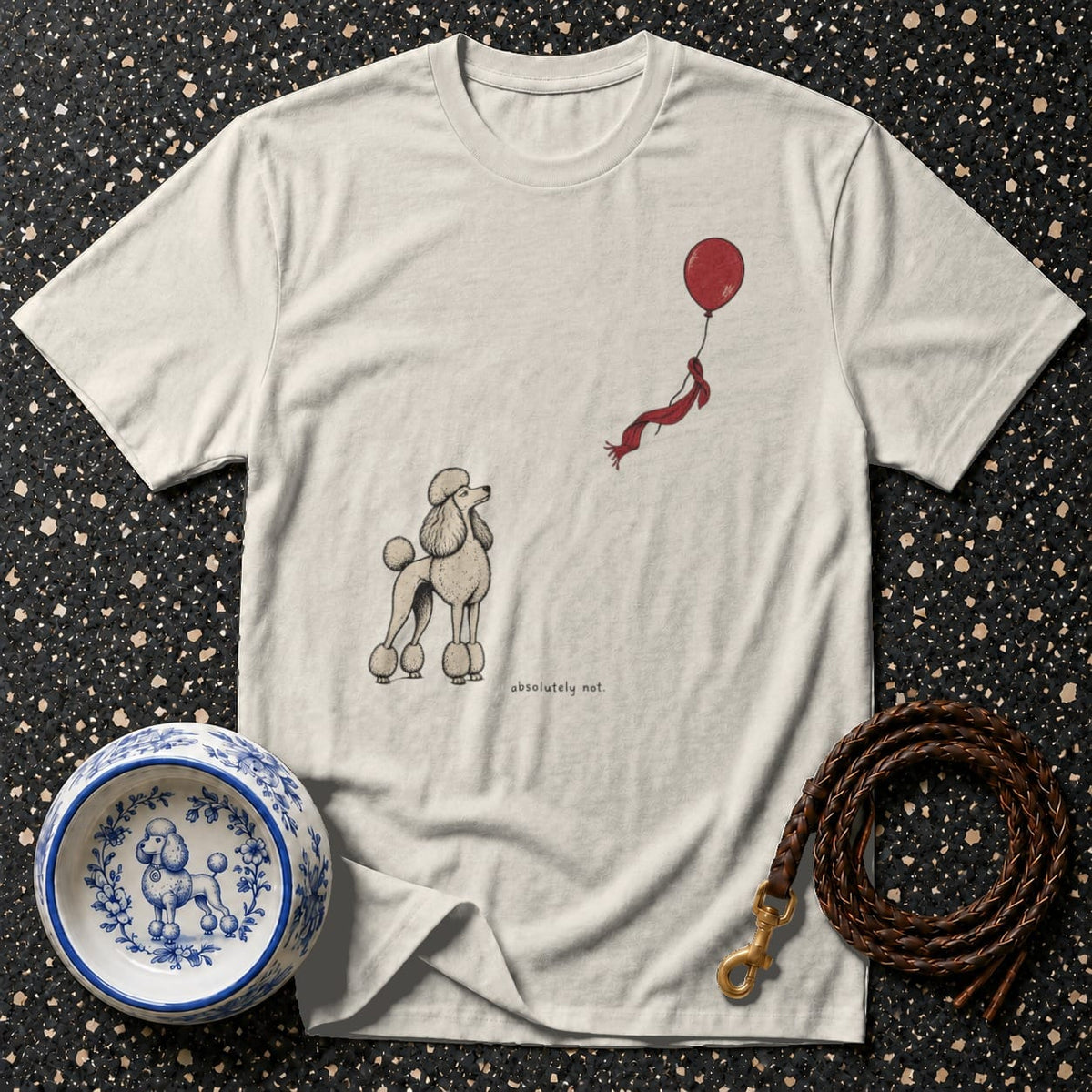 Light-colored t-shirt with a poodle illustration and a red balloon with a scarf.