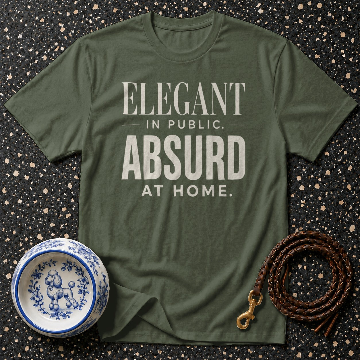 Olive green t-shirt with "Elegant in public. Absurd at home." text, poodle bowl, and leather leash.