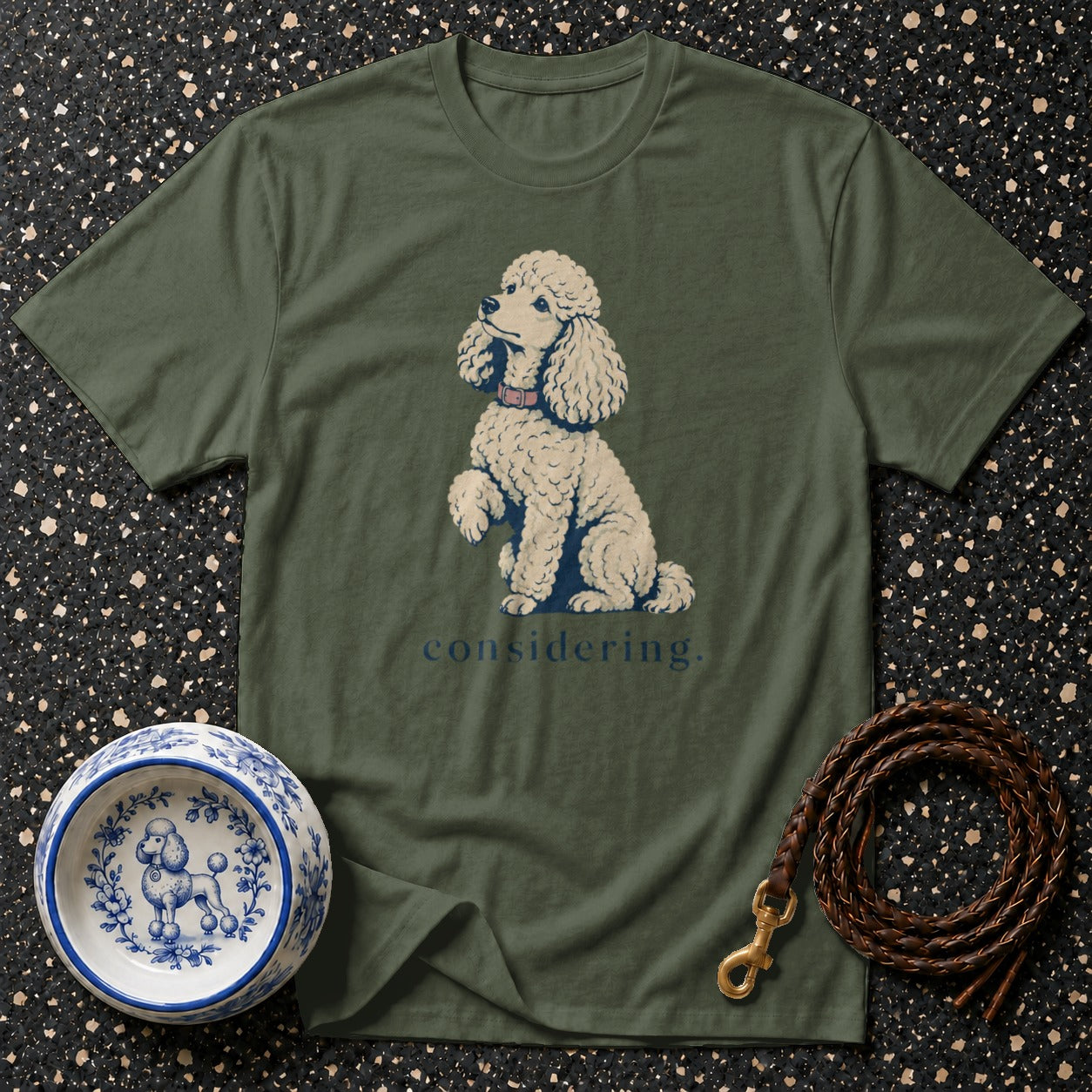 Olive green t-shirt with a cream poodle illustration and the word "considering."