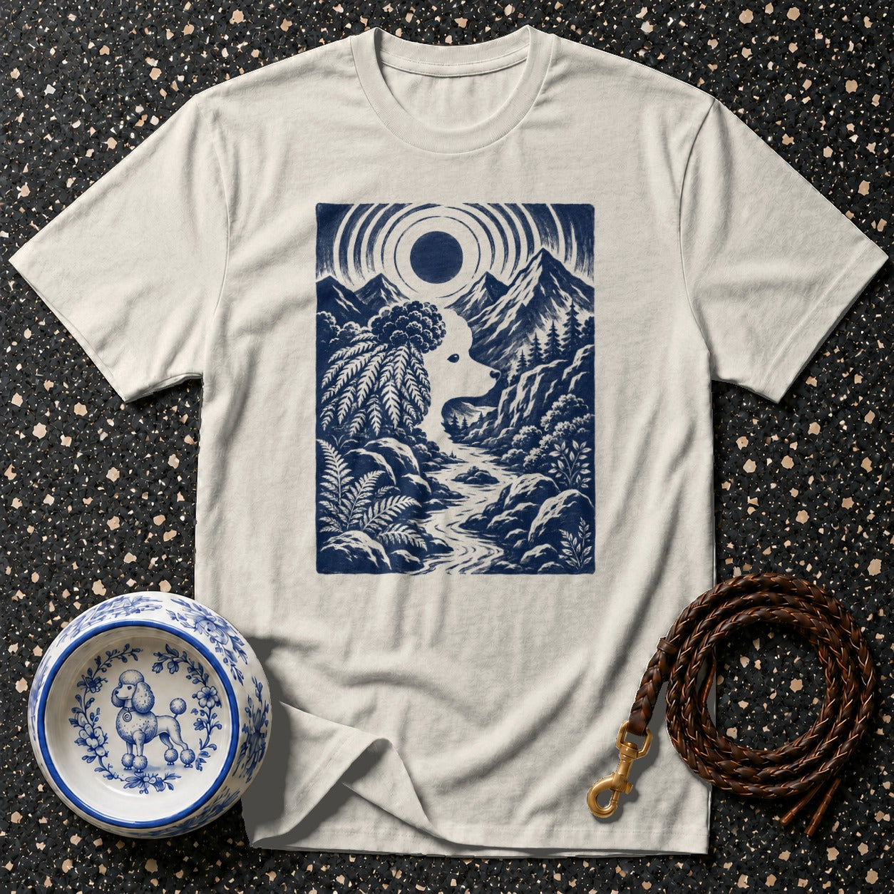 Cream t-shirt with blue graphic of a dog's profile in a mountain landscape.