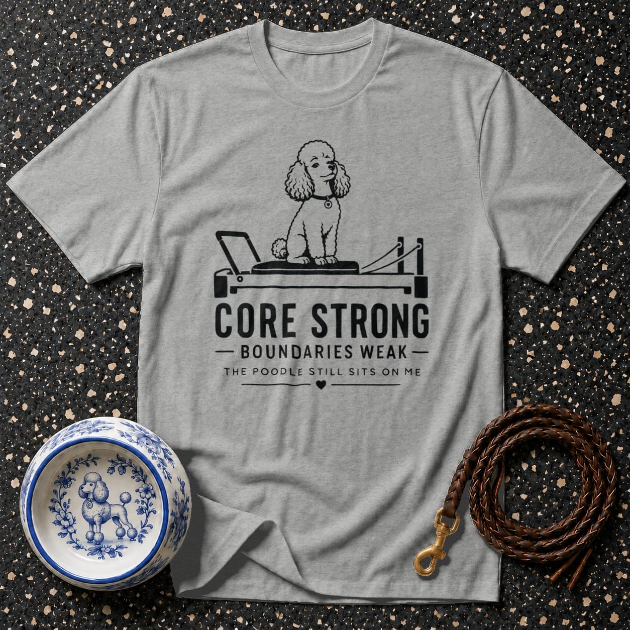 Grey t-shirt with poodle on a pilates reformer and text "Core Strong"