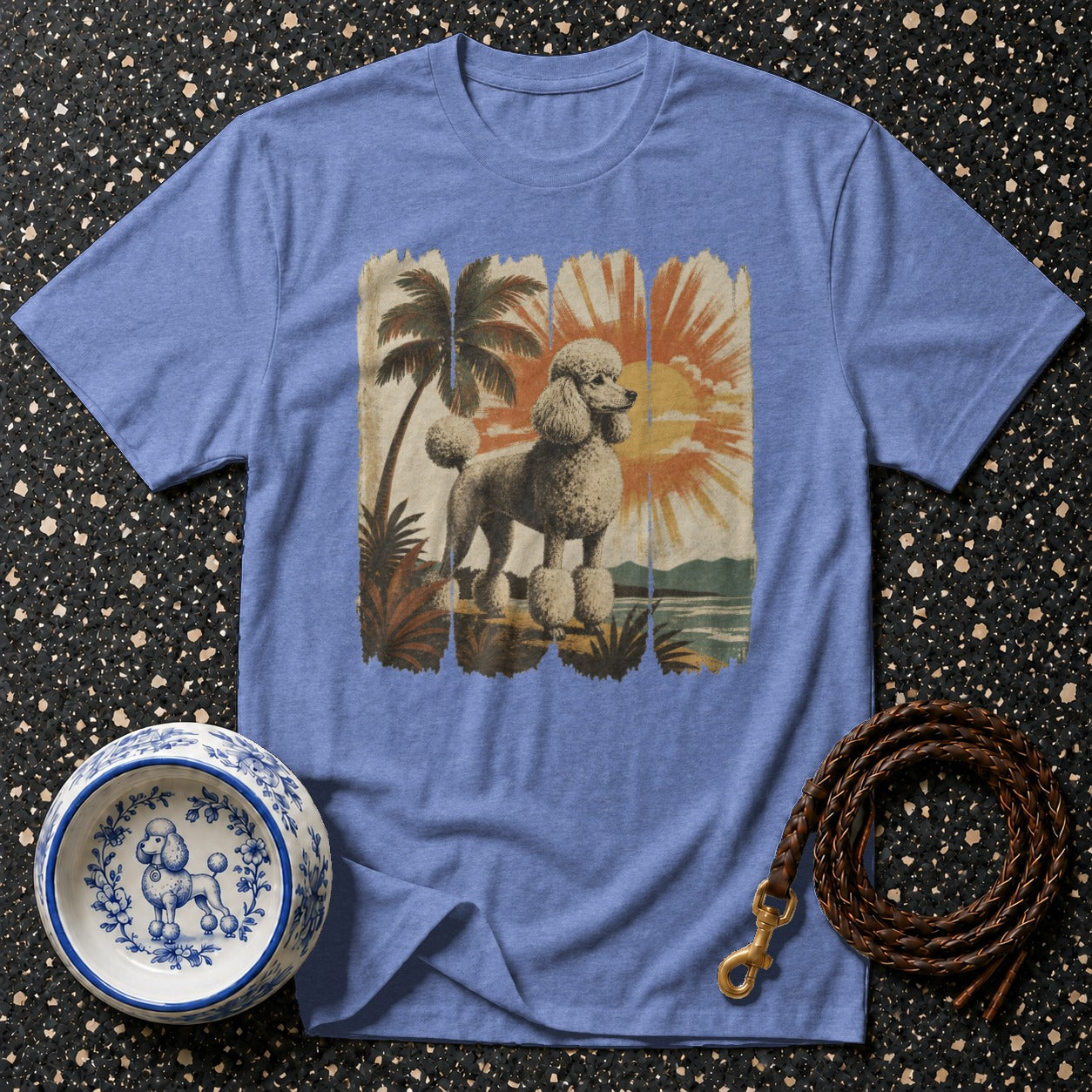Blue t-shirt with a distressed graphic of a poodle on a tropical beach at sunset.