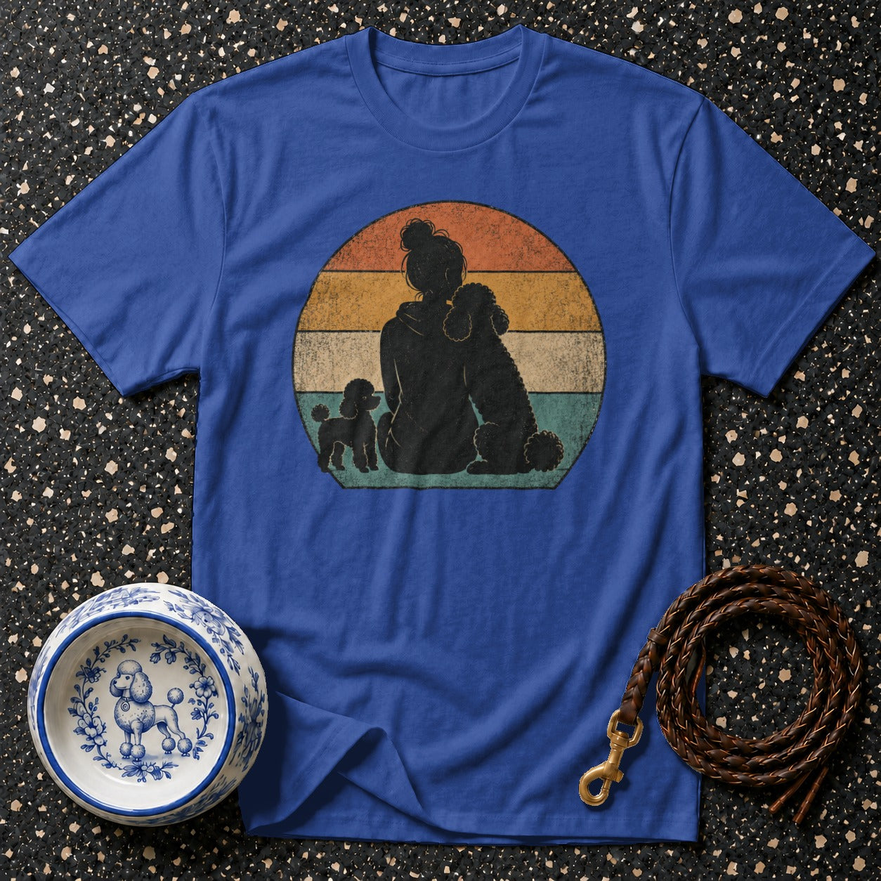 Royal blue t-shirt with silhouette of person and three poodles against retro sunset.