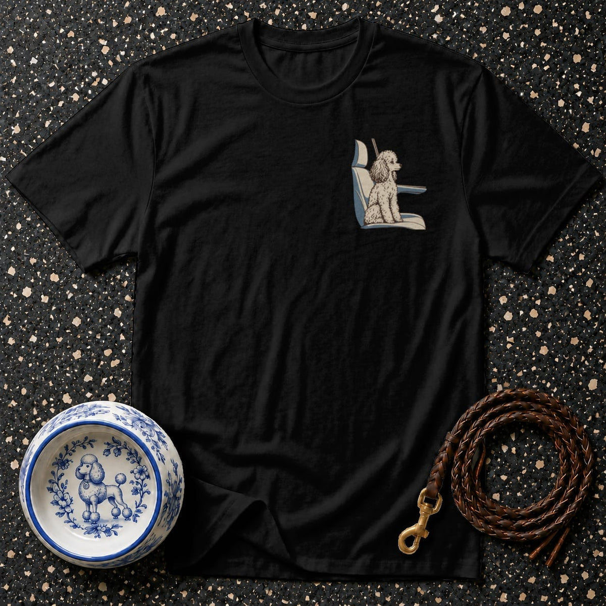 Black t-shirt with a poodle illustration on a car seat in the pocket area.