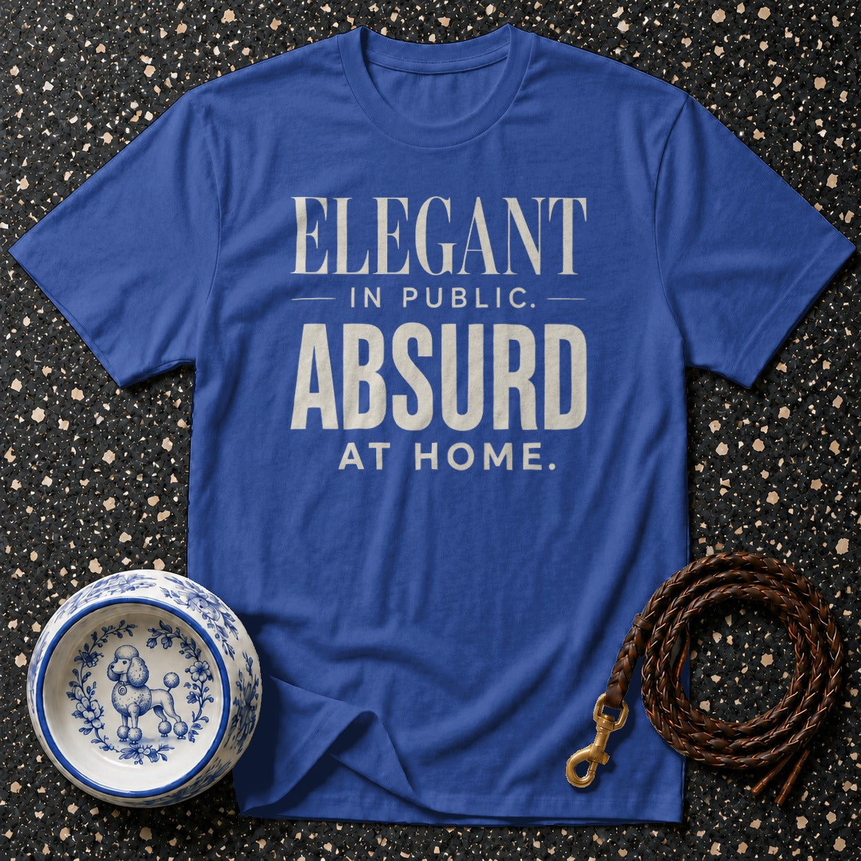 Blue t-shirt with "Elegant in Public. Absurd at Home." text, dog bowl, and leash.