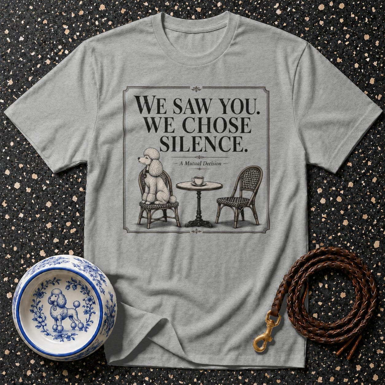Grey t-shirt with illustration of poodle at table, says "We Saw You. We Chose Silence."