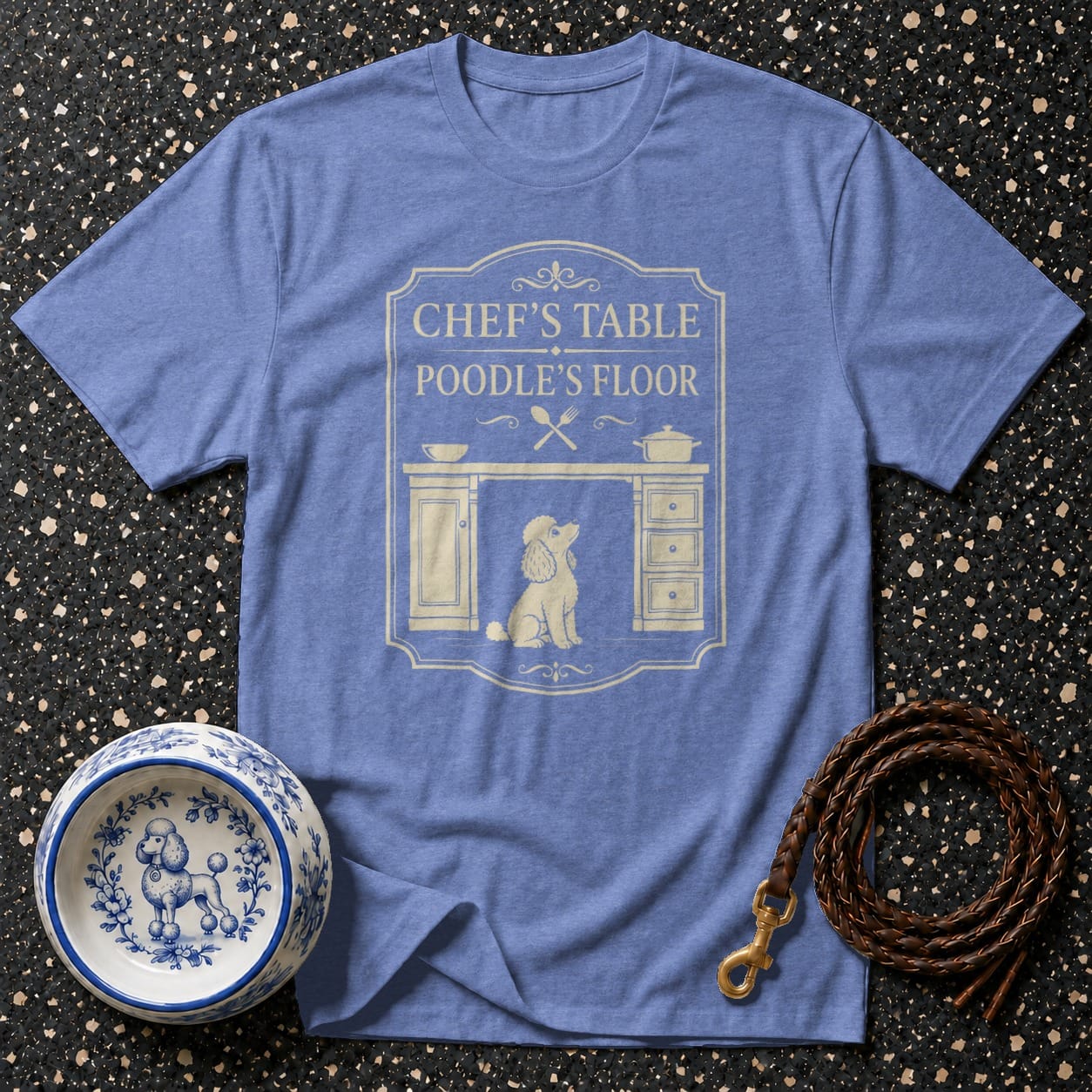 "Chef's Table Poodle's Floor" graphic on a light blue t-shirt with dog bowl and leash.