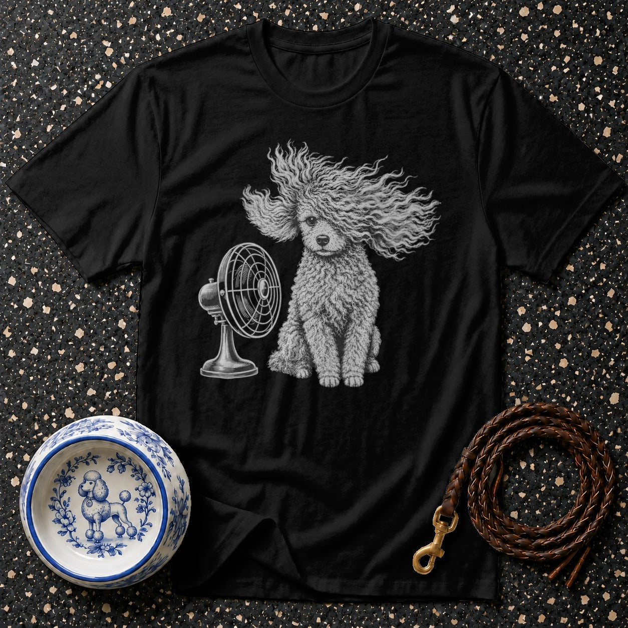 Black t-shirt with a poodle sitting by a fan and a braided leash and bowl.
