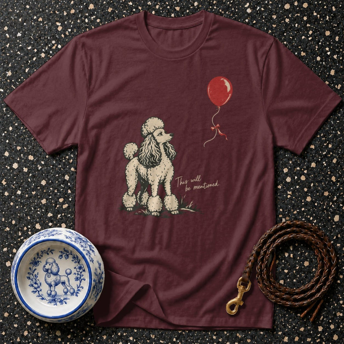 Maroon t-shirt with poodle and red balloon graphic and text.