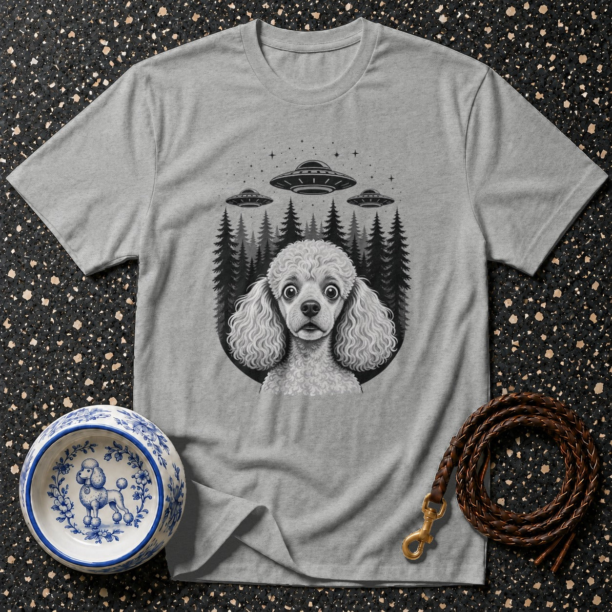 Grey t-shirt with a Poodle's face amid UFOs and dark trees.