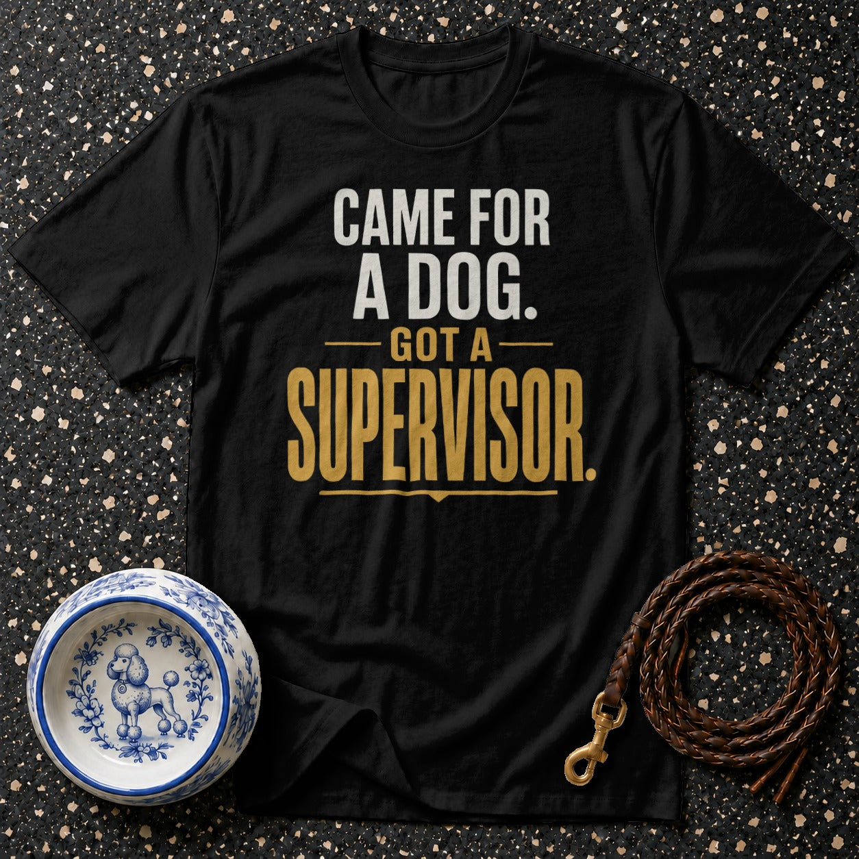 Black t-shirt with white and gold text "CAME FOR A DOG. GOT A SUPERVISOR."