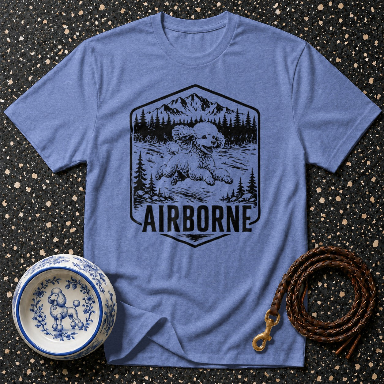 Blue t-shirt with "AIRBORNE" text and a dog in a mountain landscape graphic.