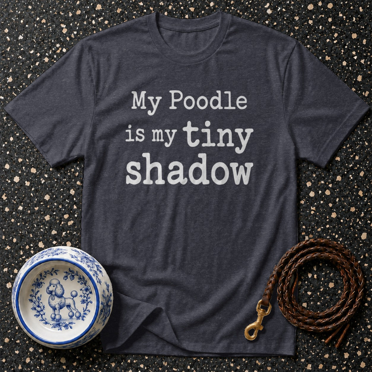 Dark t-shirt with white text "My Poodle is my tiny shadow", dog bowl, and leash.