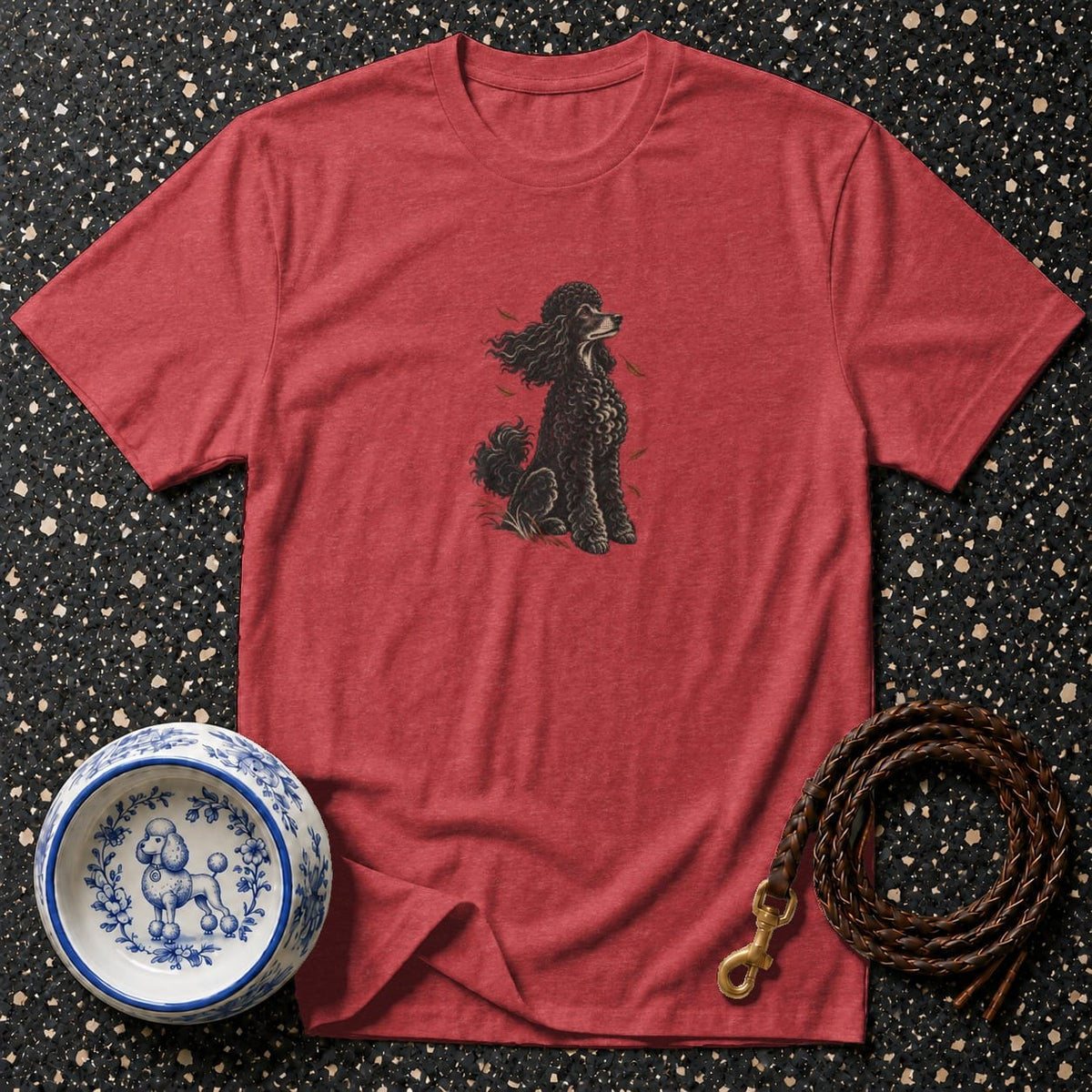 Red t-shirt with black poodle graphic, blue and white dog bowl, and leather leash.