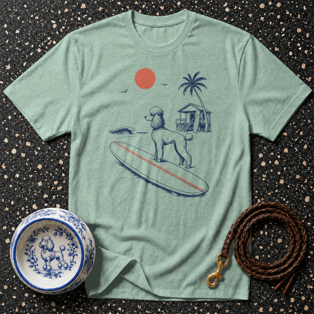 Light blue t-shirt with poodle surfing graphic, dog bowl, and leash.
