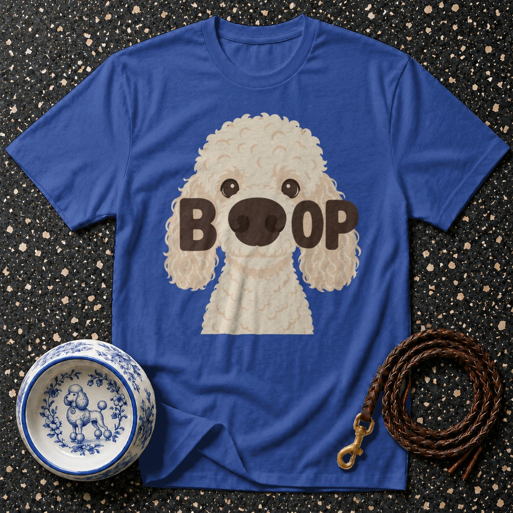 Blue t-shirt with cartoon poodle graphic and "BOOP" text, next to dog bowl and leash.