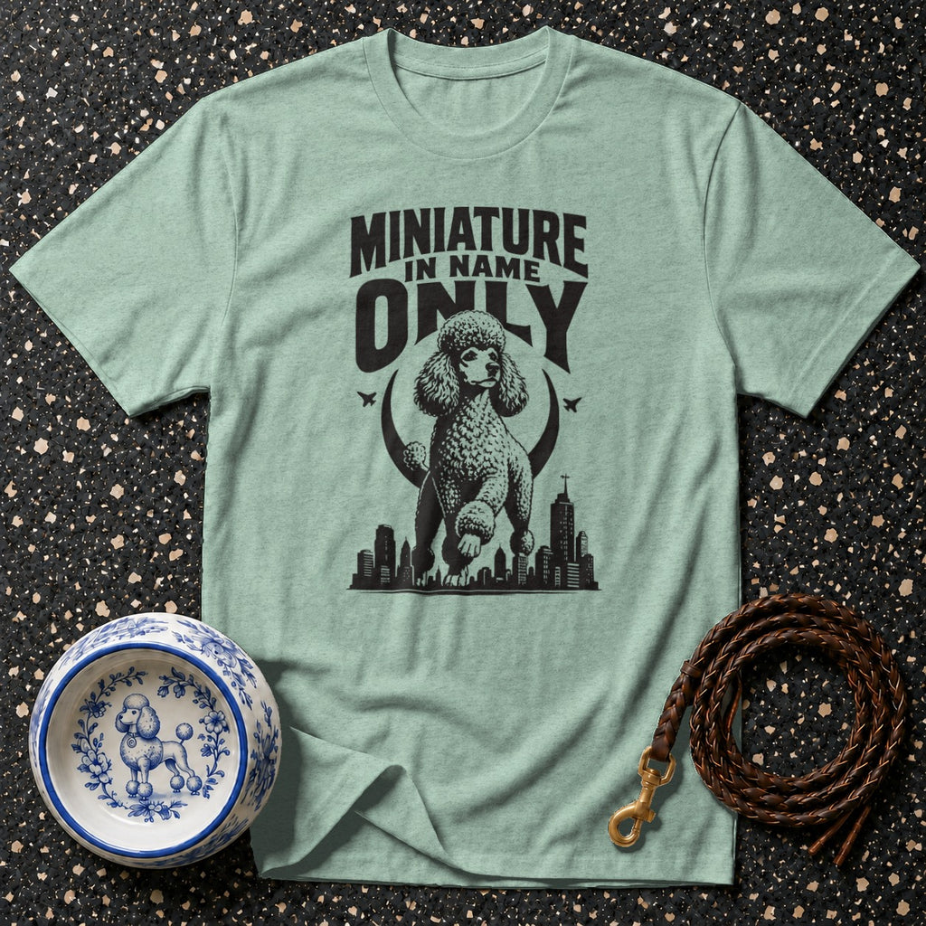 T-shirt with graphic of poodle, "MINIATURE IN NAME ONLY" text, city skyline, dog bowl, and leash.