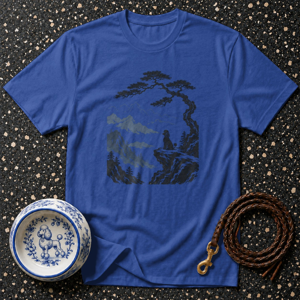 Blue t-shirt with dark graphic of dog on cliff overlooking mountains and dog bowl.