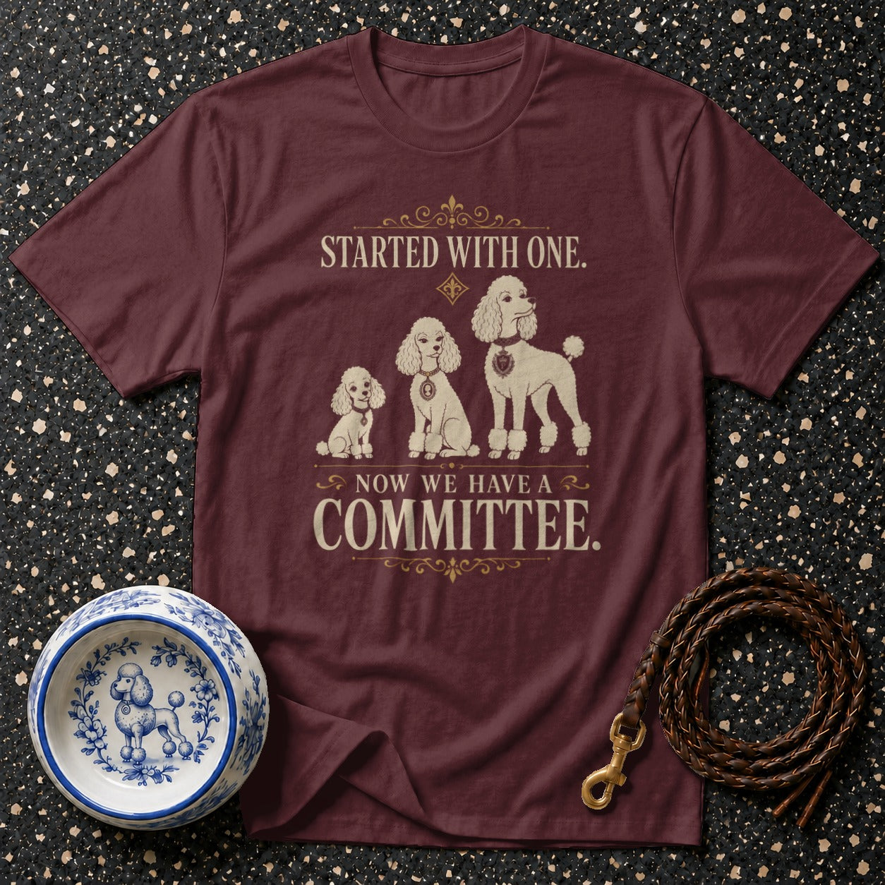 Maroon t-shirt with poodles and text: Started with one. Now we have a committee.