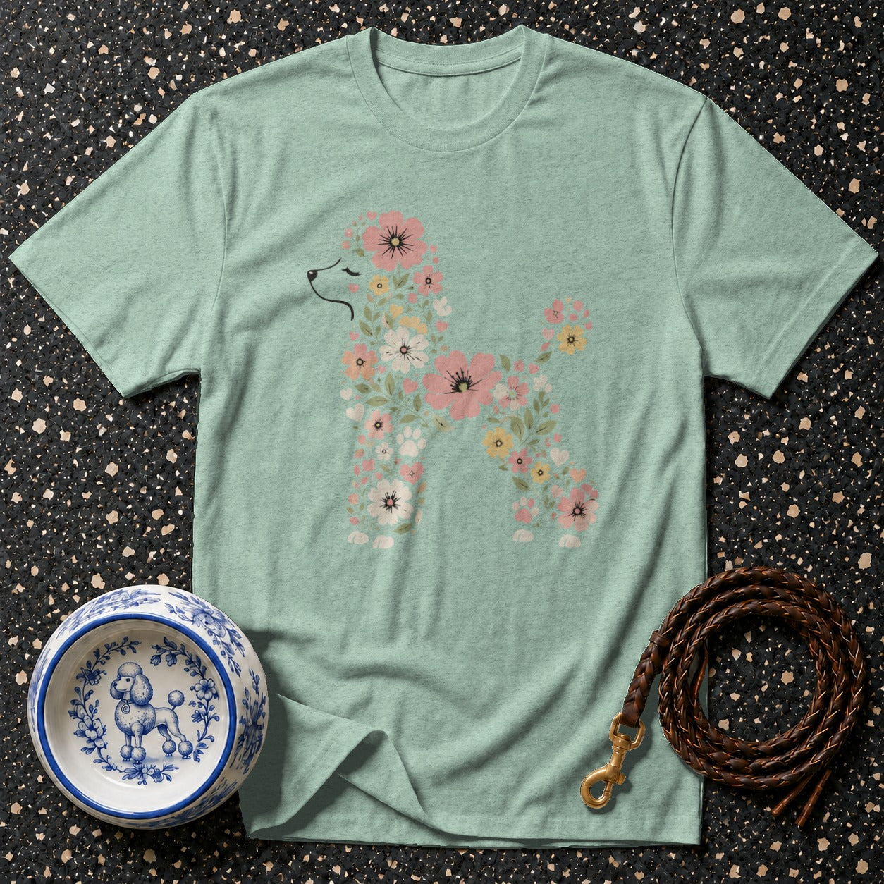Green t-shirt with a floral poodle design, a decorative dog bowl, and a braided leash.