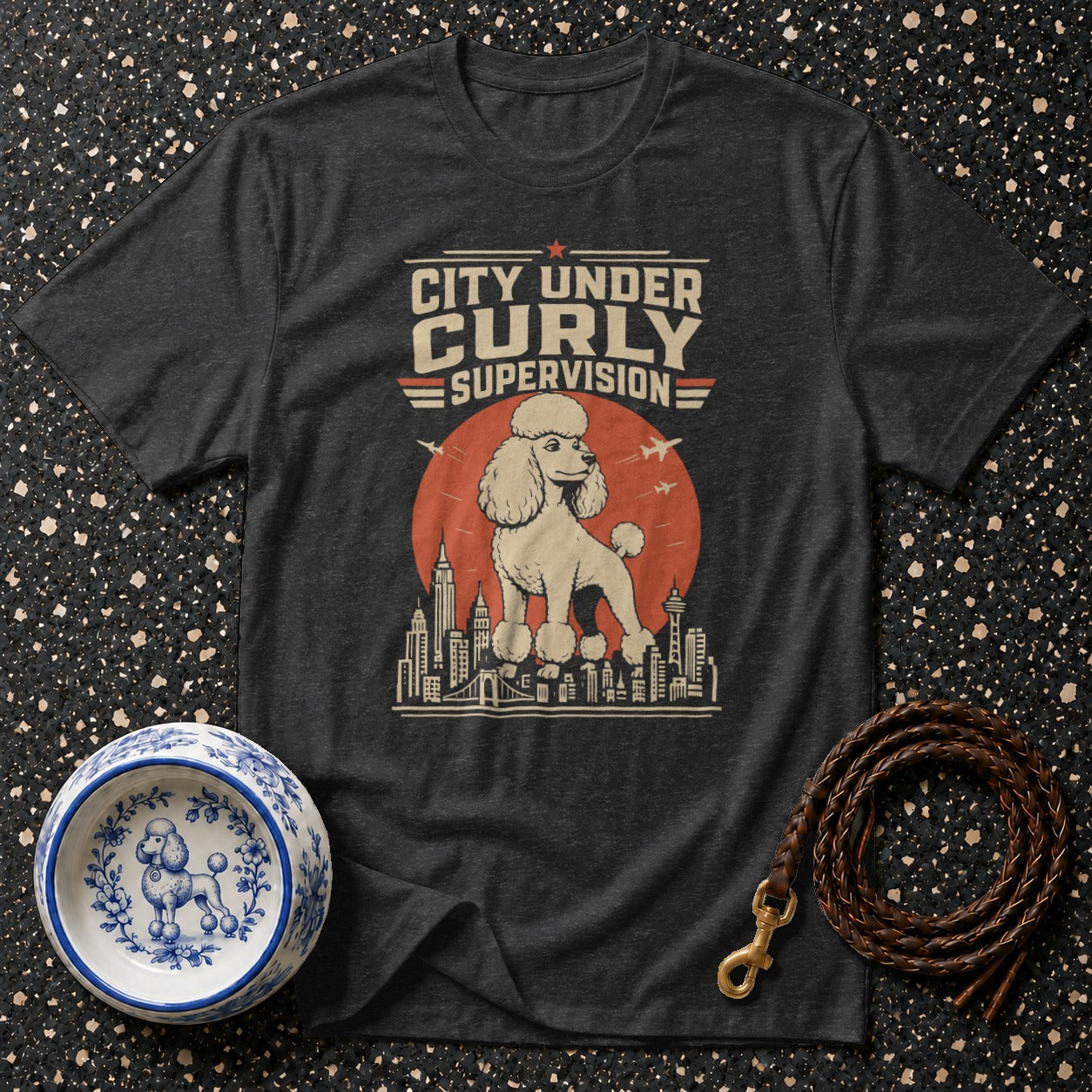 Dark t-shirt with "City Under Curly Supervision" text and poodle over city skyline.
