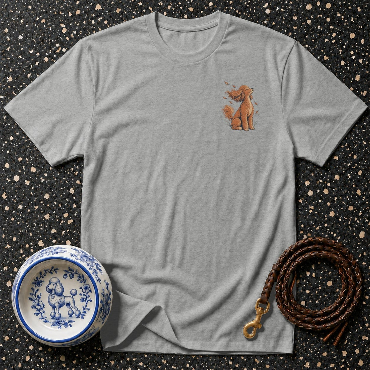 Grey t-shirt with embroidered sitting poodle and falling leaves design.
