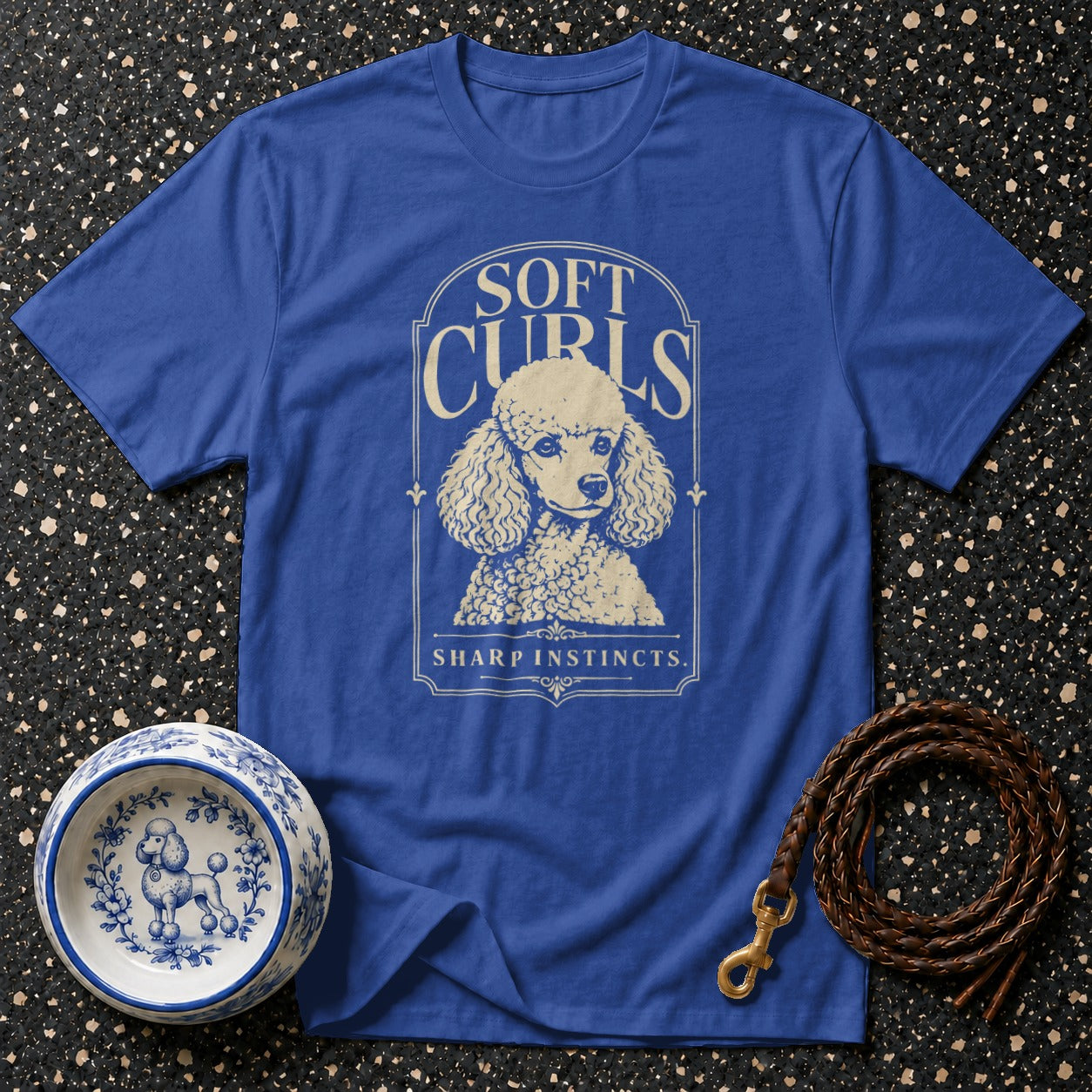 Royal blue t-shirt with poodle graphic and text "SOFT CURLS SHARP INSTINCTS."