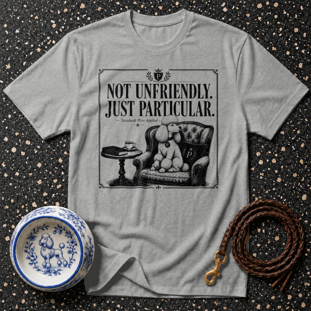 Gray t-shirt with "NOT UNFRIENDLY. JUST PARTICULAR." text and poodle illustration.