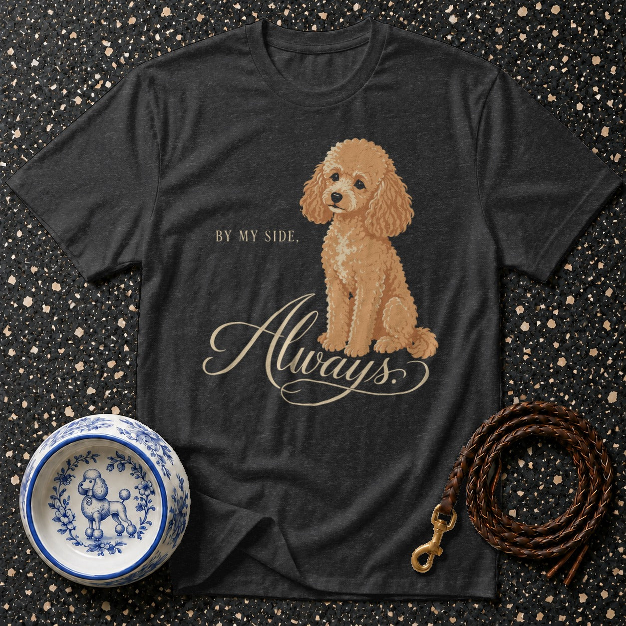 Dark t-shirt with a poodle illustration and "Always" text, beside a dog bowl and leash.