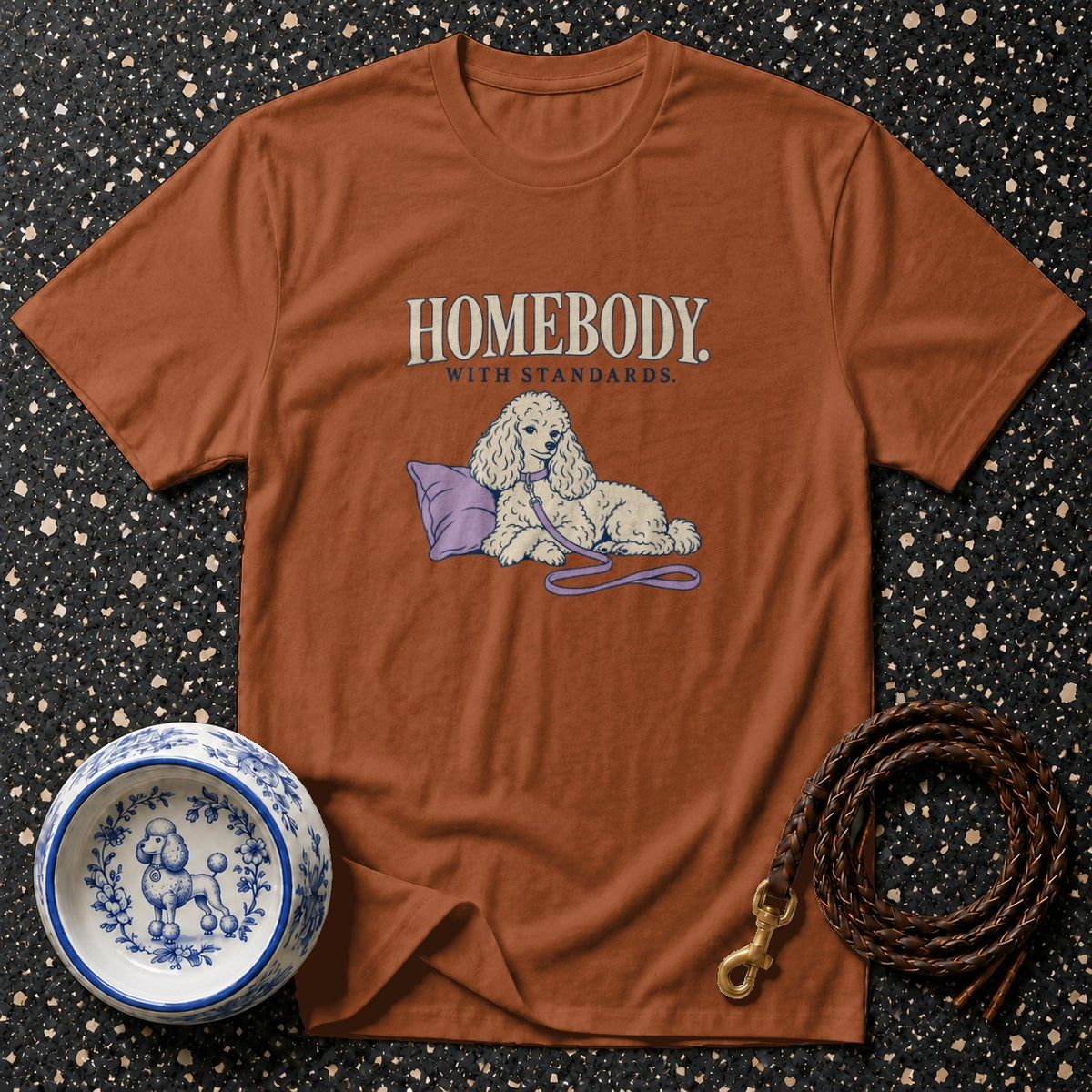 Brown t-shirt with "HOMEBODY WITH STANDARDS" and a drawing of a poodle.