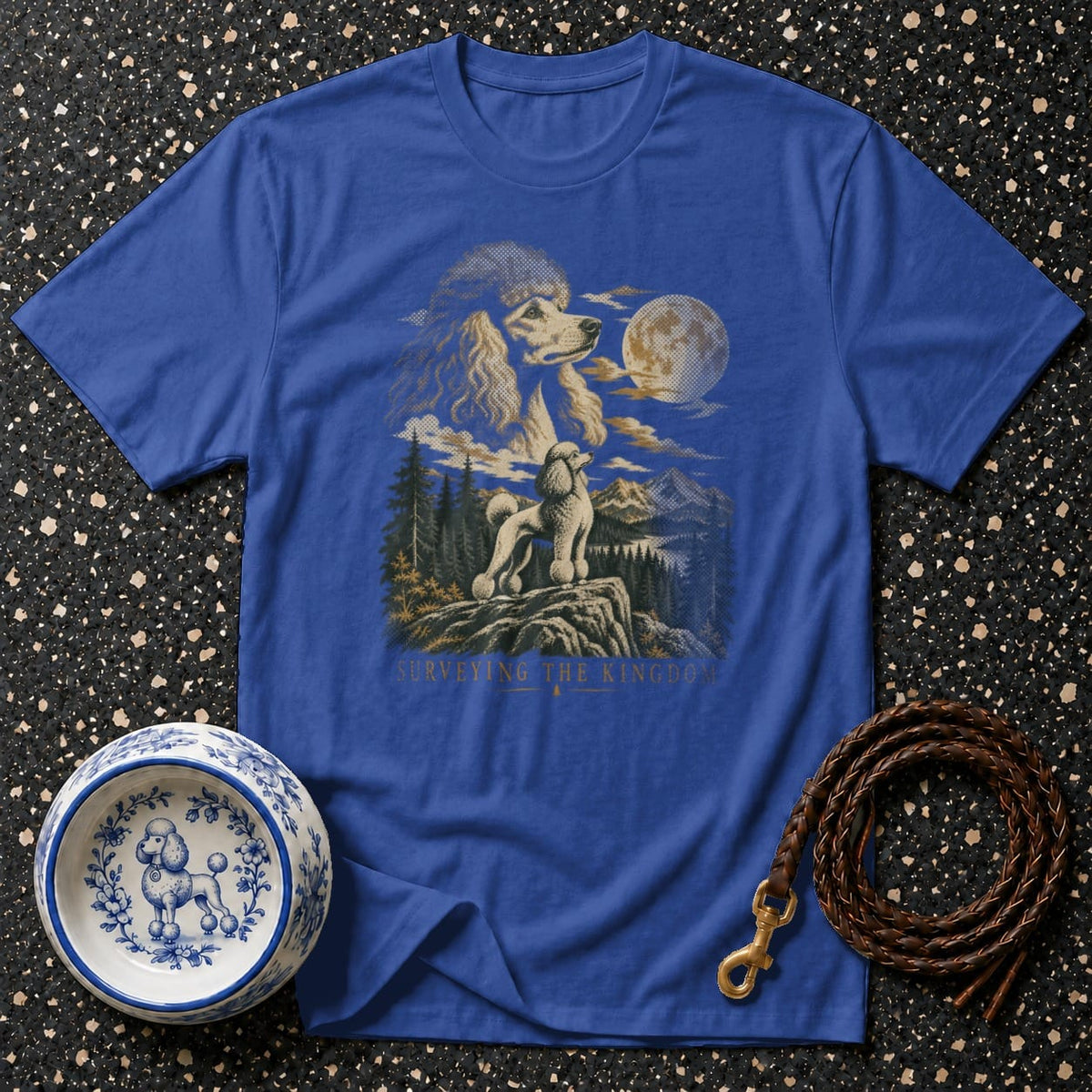 Blue t-shirt with graphic of poodles, mountains, moon, and text "Surveying the Kingdom".