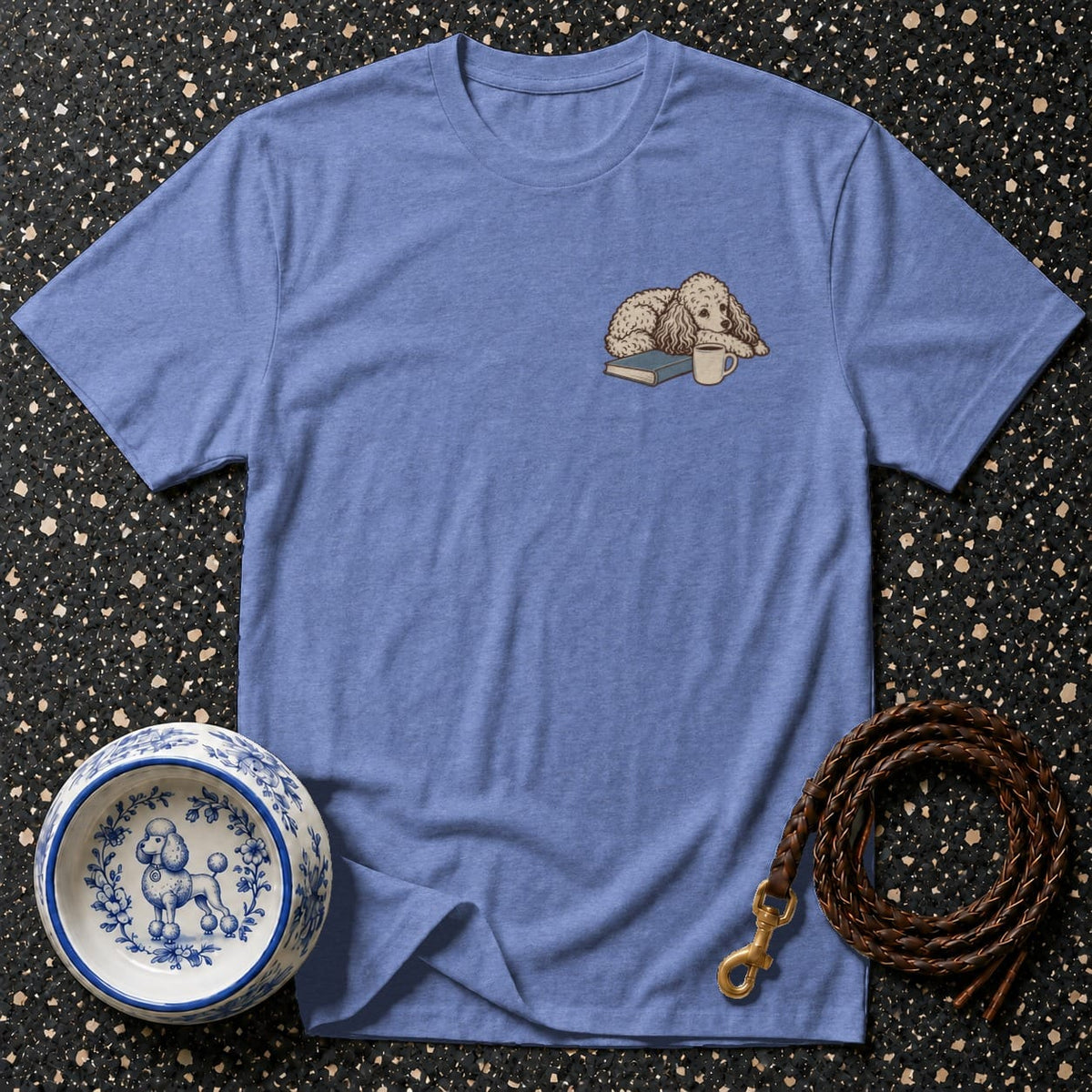 Blue t-shirt with a drawing of a poodle on a book with a coffee cup.