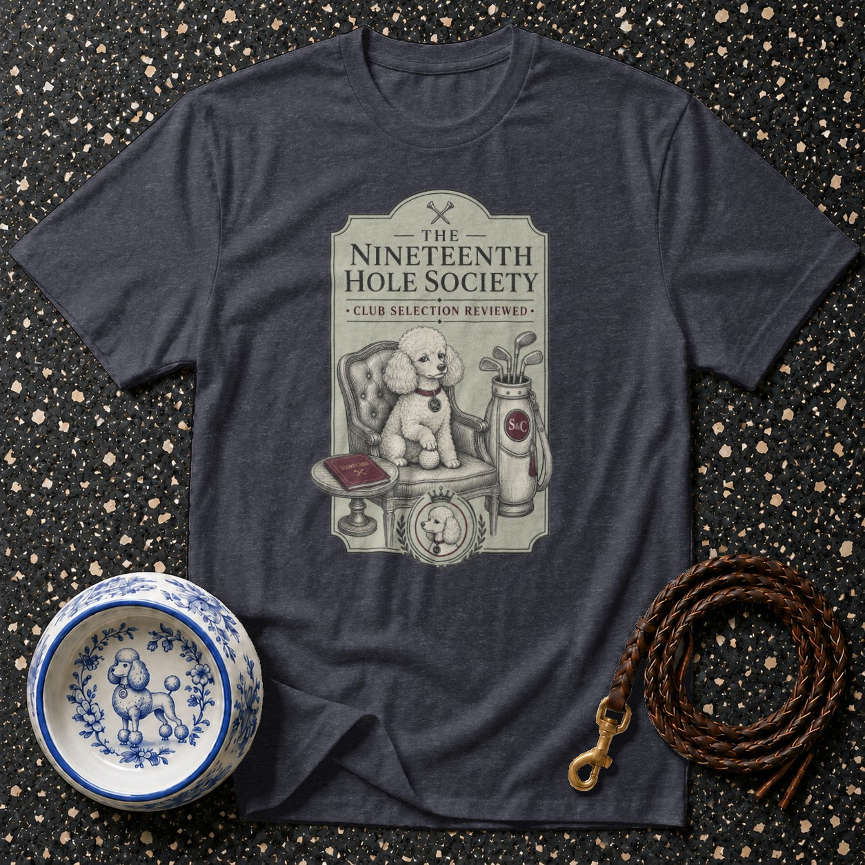 T-shirt with "The Nineteenth Hole Society" graphic featuring a poodle, golf bag, and scorecard.