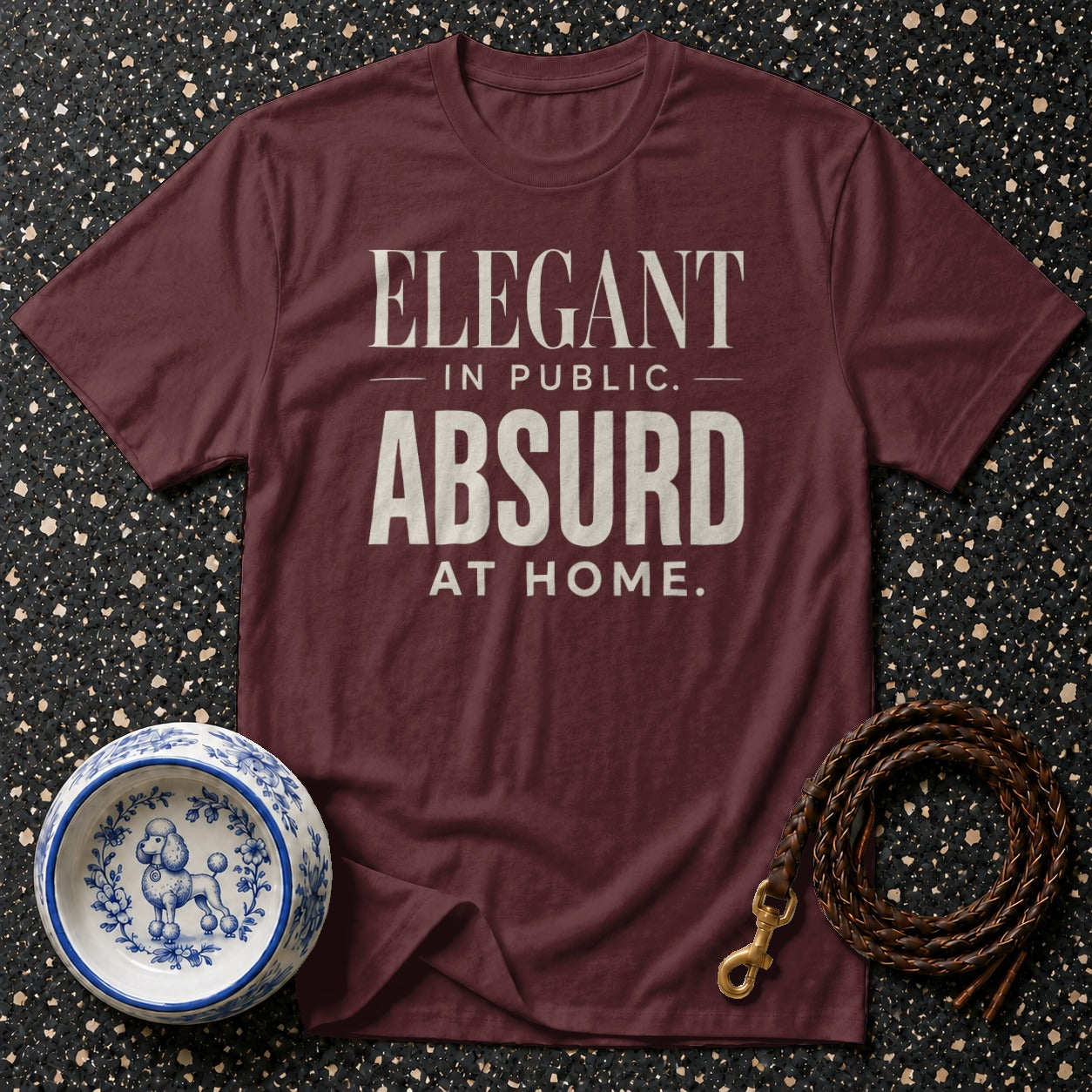 Maroon t-shirt with "Elegant in Public. Absurd at Home." text.