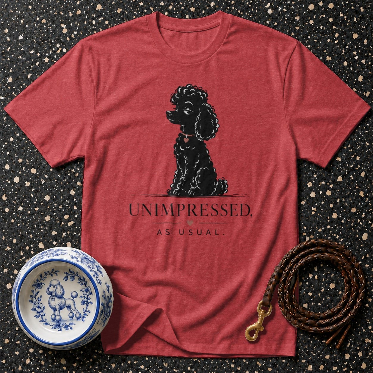 Red t-shirt with graphic of a black poodle and text "UNIMPRESSED, AS USUAL."
