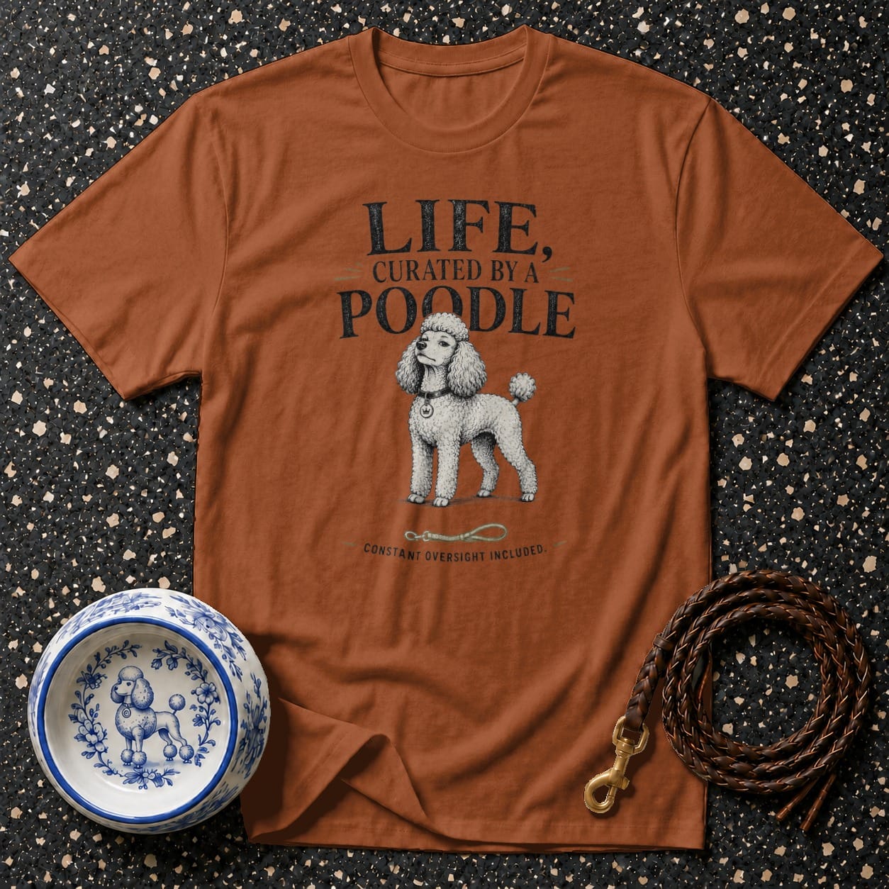 Brown t-shirt with vintage poodle illustration and text "LIFE, CURATED BY A POODLE".