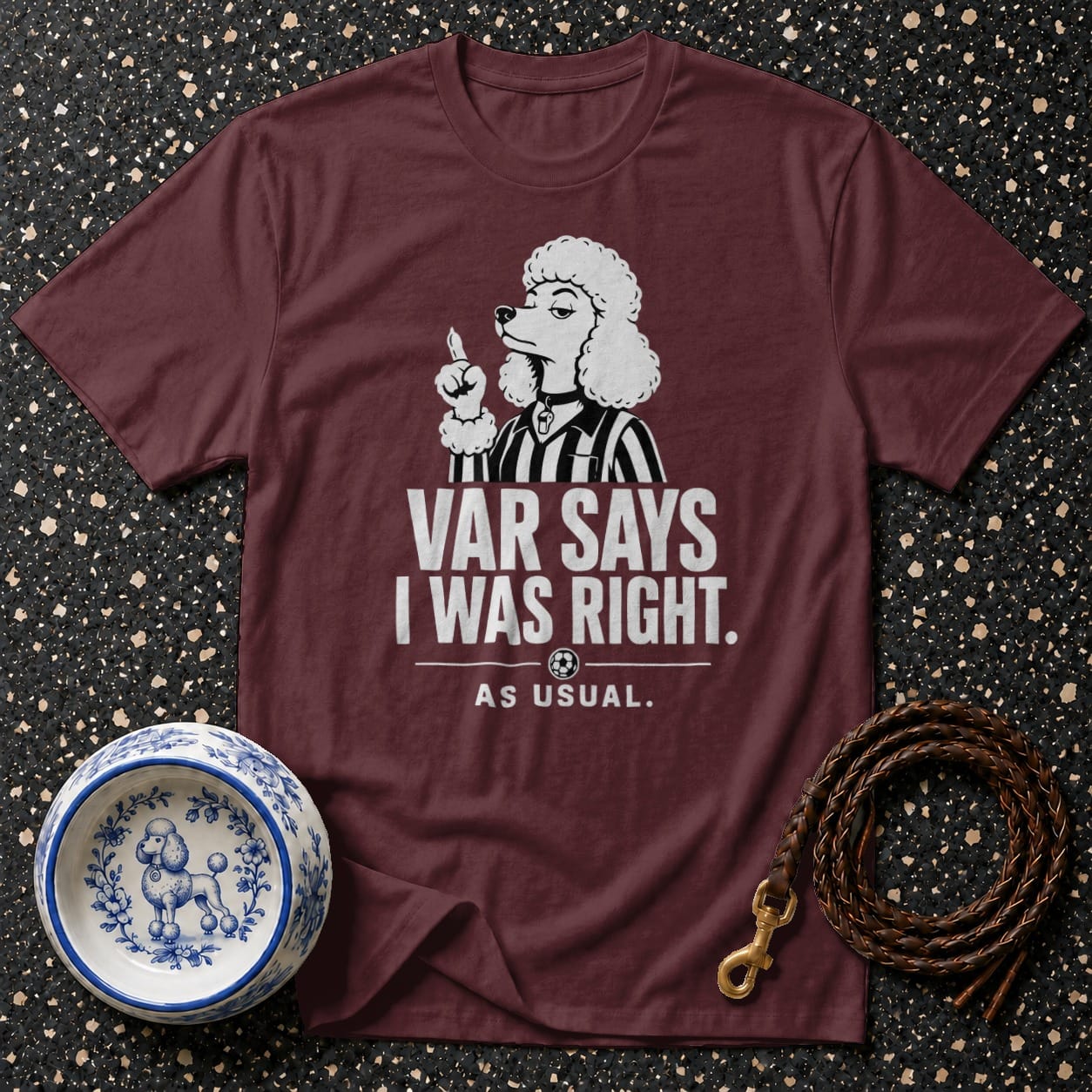 Maroon t-shirt with white text and cartoon poodle wearing referee stripes.