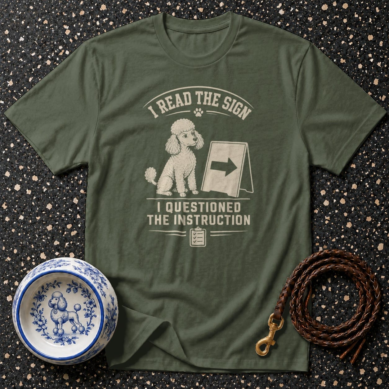 Olive green t-shirt with a poodle design and text: "I READ THE SIGN. I QUESTIONED THE INSTRUCTION."
