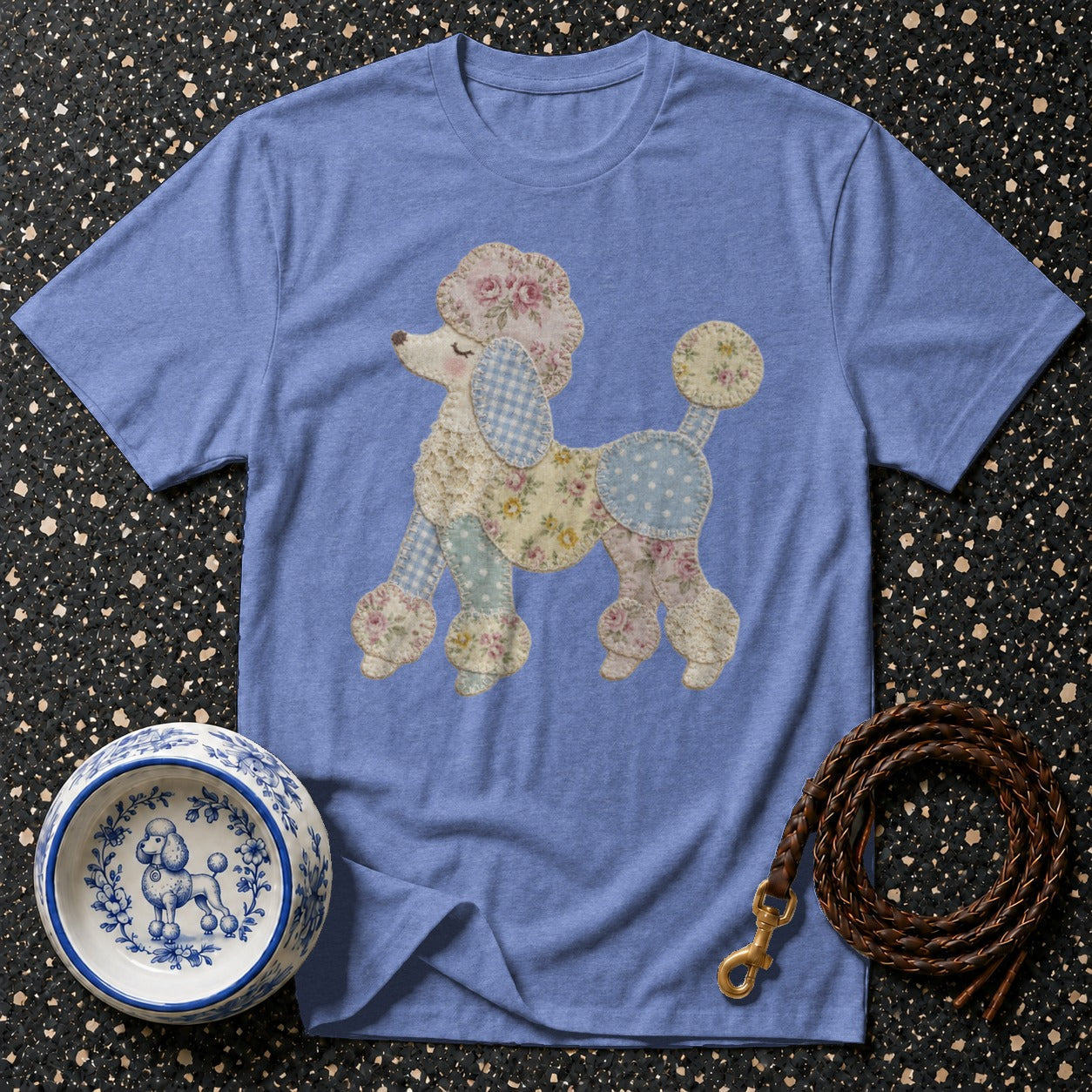 Periwinkle t-shirt with a patchwork poodle graphic, a decorative dog bowl, and a leather leash.