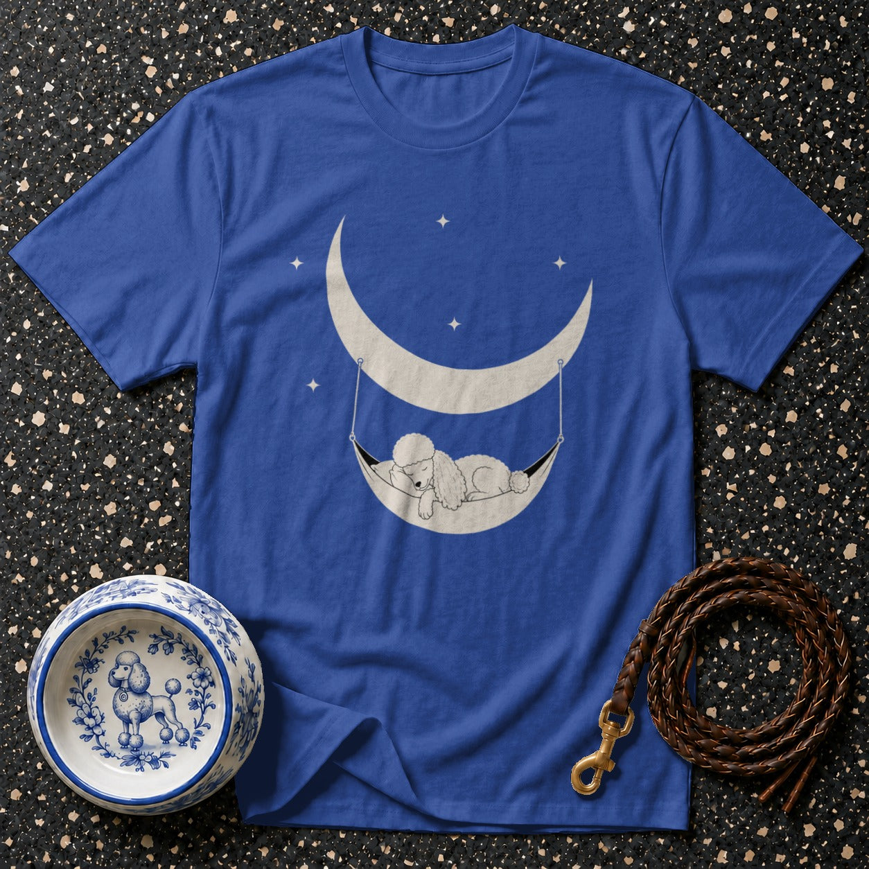 Blue t-shirt with a poodle sleeping in a crescent moon hammock graphic.