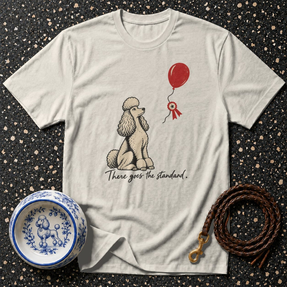 Cream t-shirt with poodle illustration, red balloon, and text "There goes the standard."